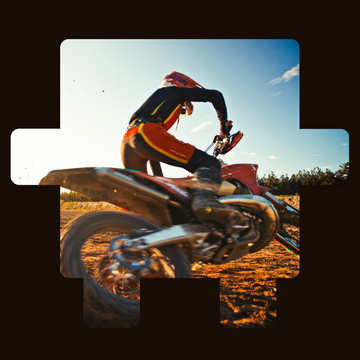 Person riding a dirt bike on a dusty trail