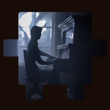 Silhouette of a person playing piano in soft light