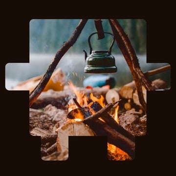 Kettle hanging over a campfire outdoors